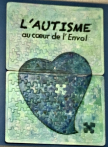 Affiche casse-tête d'un coeur avec un pièce manquante et le titre L'autisme au coeur de l'envol